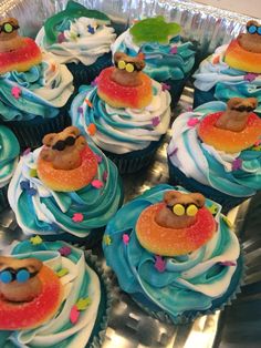 cupcakes with blue frosting and colorful decorations