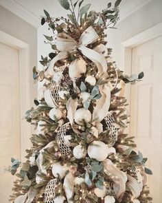 a decorated christmas tree with white and gold ornaments