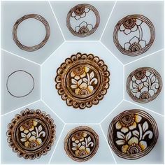 a bunch of different circular designs on a white surface with some brown and yellow flowers