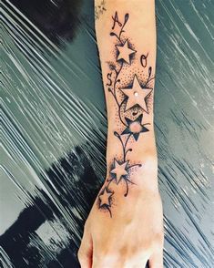 a woman's foot with stars and music notes tattoo on her left arm,