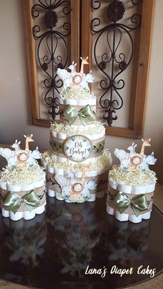 a three tiered cake sitting on top of a table next to two smaller cakes