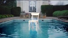 a white chair sitting in the middle of a pool