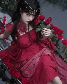 a woman in a red dress sitting on a bench with roses