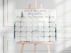 a wooden easel with a calendar on it that says guess the individual date of baby's first christmas