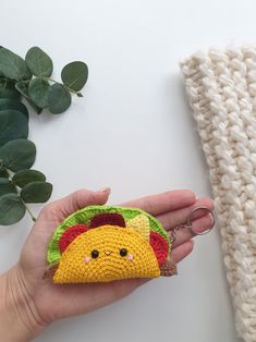 a hand holding a small crocheted animal keychain