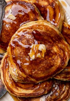 pancakes on a plate with butter and syrup drizzled over them are ready to be eaten