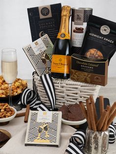 a wine and snacks gift basket with champagne, crackers, chocolates, cookies, candies