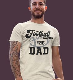 Give your football-loving dad a one-of-a-kind gift with our Personalized Football Dad Shirt. This Adult Custom Name and Number Football Player Tee is the perfect way to show your dad, papa, uncle, or nana how much you appreciate their love for the game. Not only will this shirt make a great addition to their game-day wardrobe, but it also allows you to customize it with their name and preferred jersey number. Simply choose the size and color options, and provide us with the name and number you w Football Dad Shirts Ideas, Father's Day Team Spirit Sports T-shirt, Fan Apparel T-shirt For Game Day On Father's Day, Sports T-shirt With Text Print For Father's Day, Father's Day Game Day Fan Apparel T-shirt, Father's Day Fan Apparel T-shirt With Team Name, Sporty T-shirt For Sports Events And Father's Day, Game Day T-shirt With Team Name For Father's Day, Game Day Team Spirit T-shirt For Father's Day