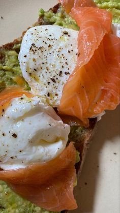 an open face sandwich with eggs, salmon and avocado on toasted bread