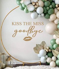 a white and green balloon arch with the words kiss the miss goodbye on it