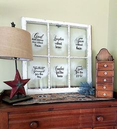 a wooden dresser with a lamp on top of it next to an old window frame