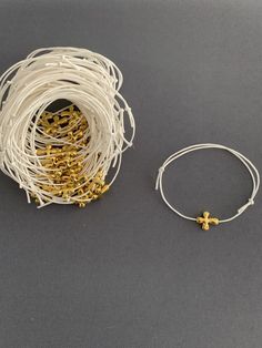 "Martyrika-Witness Bracelets- Greek Orthodox Baptism Gold Cross Wax Cord bracelets come packaged in a giftbox. What you see in the photos are samples; I will re-create your bracelets as close as I can to what you see, or in any variation you would like. Martyrika is a Greek word which means '\"sign of witnessing\". Traditionally in Greek Orthodox Baptisms, Martyrika bracelets are given to the guests upon arrival at the church as an honour for attending and witnessing a Baptism. Items sent via US White Spiritual Jewelry For Gifts, Adjustable White Jewelry For Blessing, Handmade Cross-shaped Rosary Bracelet For Blessing, Cross Bracelets With Sliding Knot For Gifts, Handmade Cross Rosary Bracelet For Blessing, White Cross Rosary Bracelet Gift, White Cross Rosary Bracelet As Gift, Spiritual Cross Bracelet For First Communion, Adjustable White Rosary Bracelet With Cross