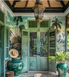 a green door with shutters and palm trees on the wall in front of it