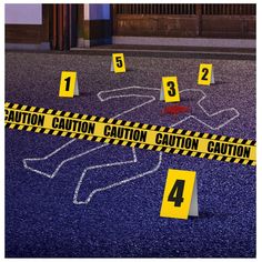 there are caution tape around the body of a person on the ground in front of a building