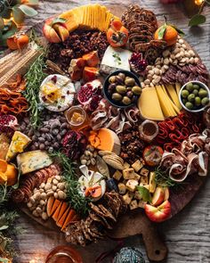 an assortment of cheeses, meats and vegetables on a platter