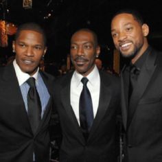 three men in suits are posing for the camera