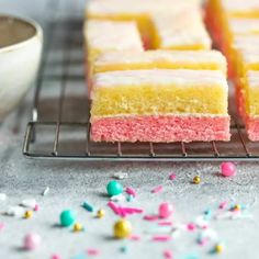 there are many pieces of cake on the cooling rack and sprinkles around it