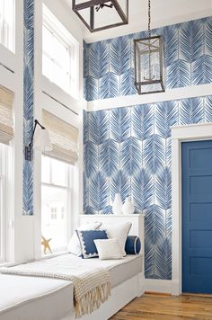 a bedroom with blue and white wallpaper on the walls, and an instagram