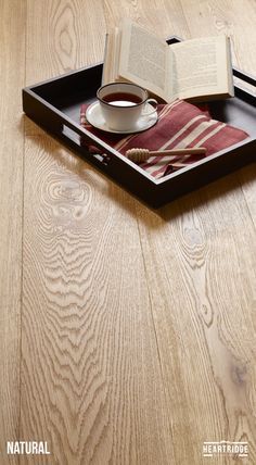 an open book on a tray with a cup of coffee