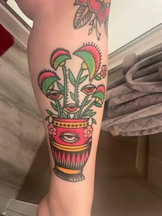 a woman's leg with a potted plant tattoo on it