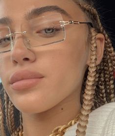 a woman with braids and glasses looking at the camera