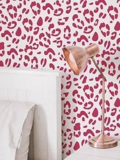 a bedroom with pink and red wallpaper, white bedding and an animal print pattern on the wall