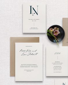 the wedding stationery is laid out on top of each other, including an envelope with a flower