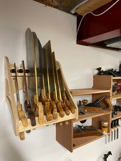 a rack filled with lots of different types of woodworking tools next to a wall