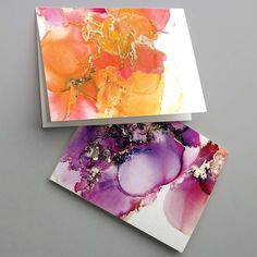 two cards with different designs on them sitting side by side, one has an orange and purple flower