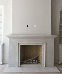 an empty living room with a fireplace and bookshelf in the corner, next to a white bookcase