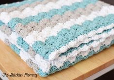 a crocheted blanket sitting on top of a wooden table