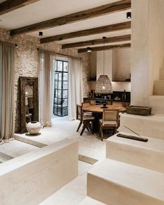 an open living area with stairs leading up to the dining room