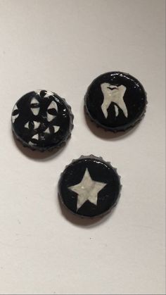 three black and white buttons with stars in the middle on a white surface, one has a star