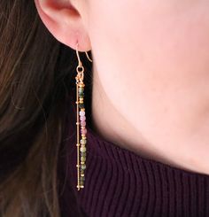 a close up of a person wearing some kind of earring with beads on it