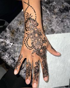 a woman's hand is decorated with hennap and intricate designs on it