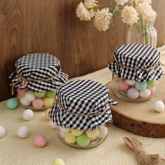 three jars filled with eggs sitting on top of a table next to flowers and other decorations