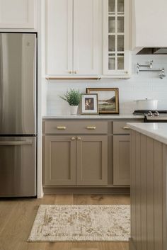 a kitchen with white cabinets and silver appliances