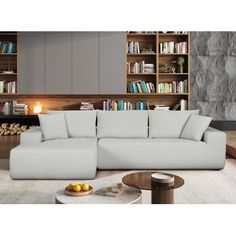 a large white couch sitting in front of a book shelf filled with lots of books