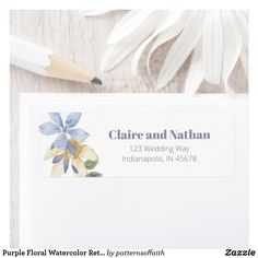 a white envelope with a blue flower on it and a pencil next to the envelope