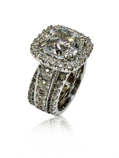 a diamond ring with two rows of diamonds on the band and an oval shaped center