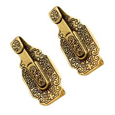 two gold tone metal clippers with intricate designs