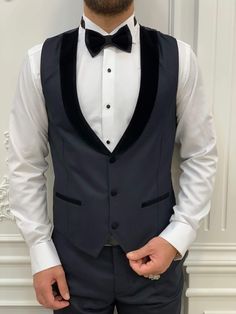 We're featuring a slim-fit buttoned shawl collar dark navy blue tuxedo. From the HolloMen fall-winter '23 collection. Tuxedo Color: Dark Navy Blue The suit's fabric includes 65% Polyester, 32% Viscone, and 3% Lycra. Its jacket has a shawl collar, double slits, flap pockets, and single buttons and it is fully canvassed. Suit Care Instructions: Dry clean only In your package, we will include a jacket, vest, pants, shirt, and bow tie. Our model wears EU50/US40. His height and weight are 180cm by 78 Winter Black Tuxedo With Pressed Crease, Winter Black Tie Tuxedo With Notch Lapel, Navy Tuxedo Style Three-piece Suit For Formal Occasions, Navy Tuxedo For Formal Occasions, Black Single Button Tuxedo For Winter, Navy Three-piece Tuxedo For Formal Occasions, Luxury Fitted Navy Tuxedo, Elegant Winter Slim Fit Three-piece Suit, Elegant Winter Three-piece Suit Slim Fit