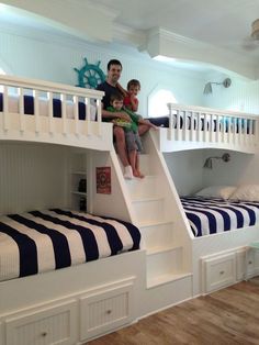 two children sitting on top of bunk beds in a room with white walls and wooden floors