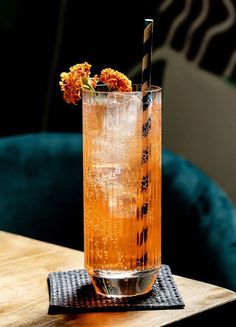 a tall glass filled with ice and orange flowers