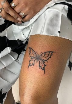 a woman with a butterfly tattoo on her thigh