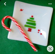 a candy cane sitting on top of a white plate