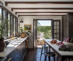 an open kitchen with lots of counter space and plants in the window sill area