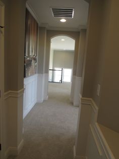 an empty hallway with white walls and carpet