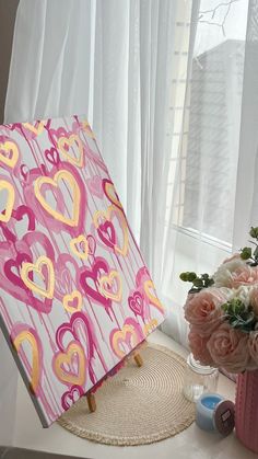 a pink and yellow umbrella sitting on top of a table next to a vase with flowers