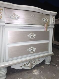 a white and silver dresser sitting on top of a floor